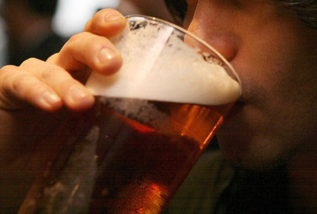 A close-up of a man drinking a pint