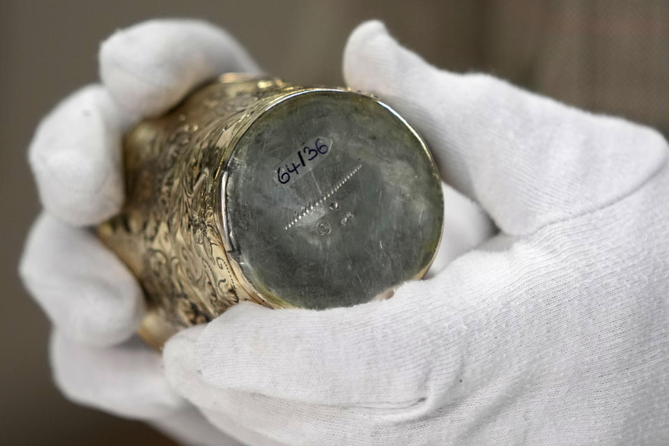 Matthias Weniger, curator of the Bavarian National Museum, shows one of the 111 registered silver objects stolen by the Nazis from the Jews during the Third Reich, in Munich, Germany, Saturday, June 10, 2023. Museum staff have made it their mission to return as many of the silver objects as possible to the descendants of the original owners. (AP Photo/Matthias Schrader)