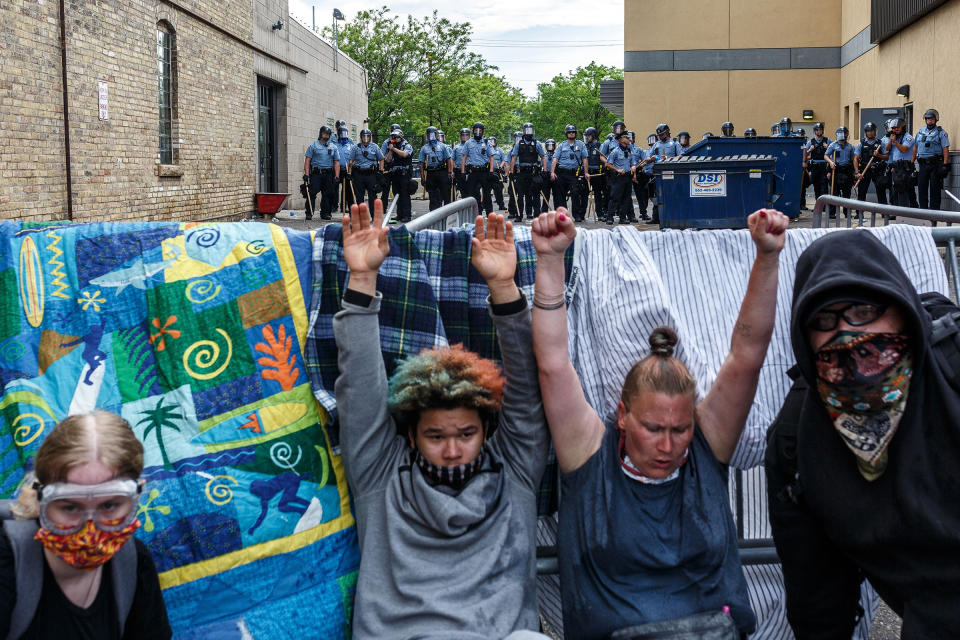 Protesters hold their hands up as they cry from from tear gas during a demonstration calling for justice for George Floyd on May 27, two days after his death. | Kerem Yücel—AFP/Getty Images