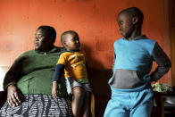 <p>Wendy, a single mother, with her two children in their home. Wendy lives in Langa, the oldest township in the suburbs of Cape Town, and suffers from diabetes caused by obesity. Her diet is mainly made up of fried foods, red meat, and meals purchased at fast food restaurants. Her two children say that their diet consists of chips, fast food dishes, and sweets. (Photograph by Silvia Landi) </p>