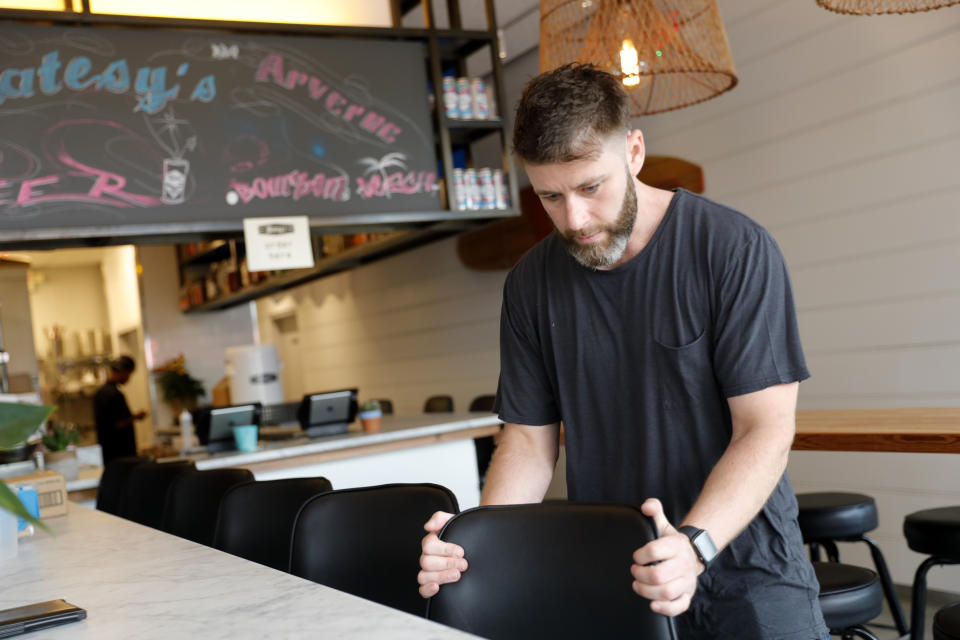 In this Thursday, Sept. 12, 2019 photo, Chris Miles helps to prepare his restaurant, Batesy's, for opening in the Rockaway section of New York. Businesses and homeowners are getting caught in the middle as a utility presses state regulators to approve a natural gas pipeline between New York and New Jersey. The showdown has hurt people like Miles, whose new barbecue restaurant in Rockaway Beach missed the summer season after it was denied a new gas hookup. (AP Photo/Seth Wenig)