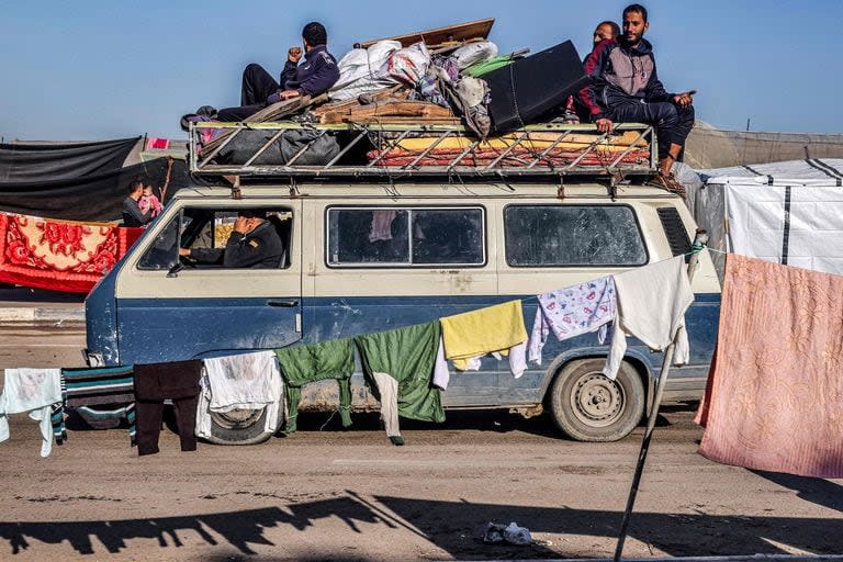 Un minibús que transporta a personas que huyen del centro de la Franja de Gaza con sus pertenencias llega a Rafah, en el sur de la Franja de Gaza, siguiendo una orden de evacuación el 26 de diciembre de 2023.