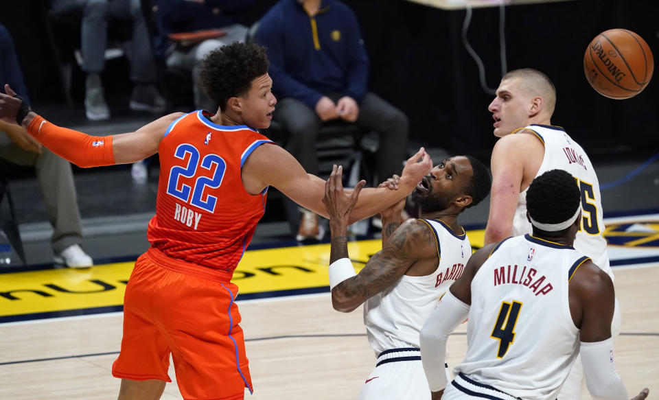 Oklahoma City Thunder forward Isaiah Roby, left, reaches out for a loose ball as it bounds past Denver Nuggets forward Will Barton, second from left, and forward Paul Millsap, front right, and center Nikola Jokic in the second half of an NBA basketball game Tuesday, Jan. 19, 2021, in Denver. (AP Photo/David Zalubowski)