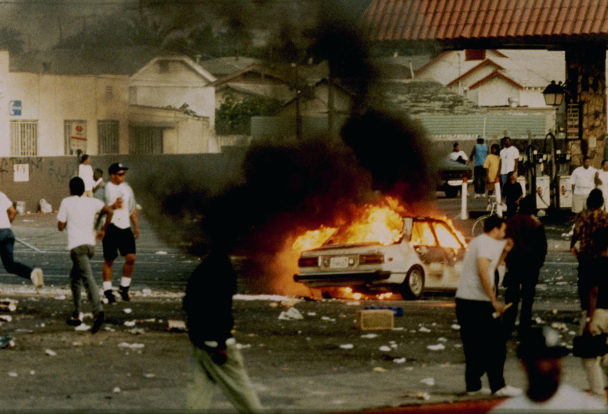 A car burns as looters take to the streets at the intersection of Florence and Normandie Avenues in Los Angeles on April 29, 1992.