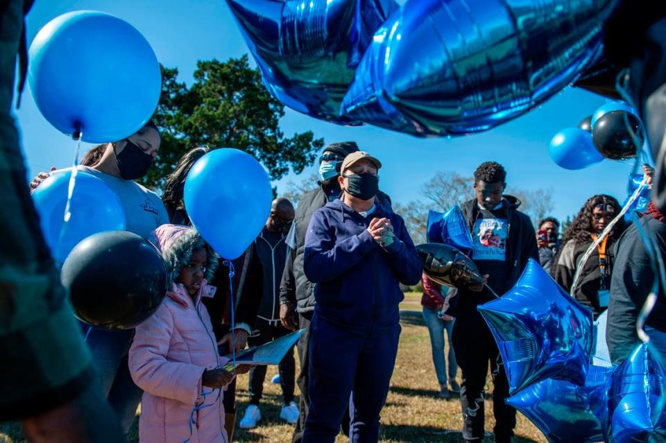 Tiffany McGary-Cyprian, 47, center, the mother of Corri Howard’s fiancé, leads a prayer during a balloon release in his honor on Monday, Jan. 17, 2022.