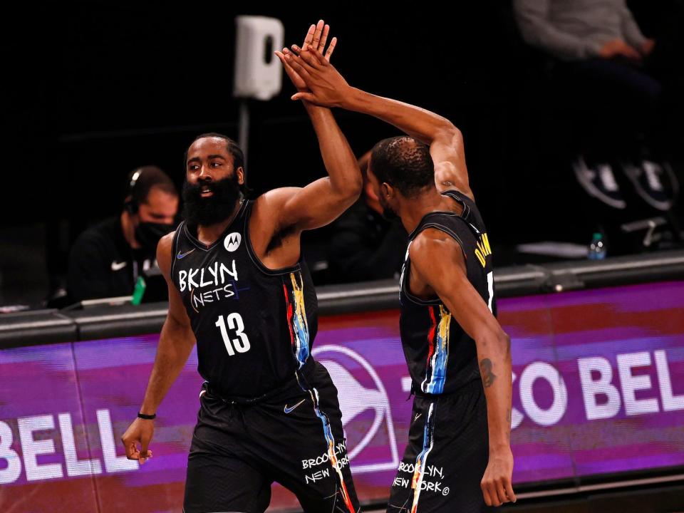 James Harden and Kevin Durant high-five during a Nets game in 2021.