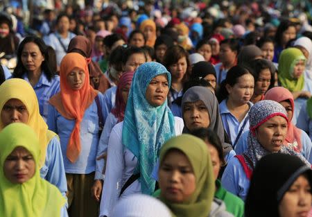 Workers of a shoe factory walk as they make their home after work, at Pasar Kemis industrial park in Tangerang August 14, 2014. REUTERS/Beawiharta