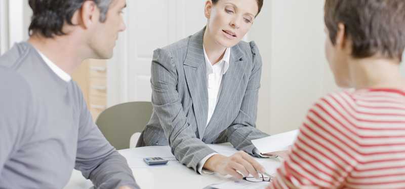 man and woman looking over documents with woman in business suit