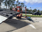An electronic highway sign lies toppled on a highway information sign pointing the way to Interstate 75, in Fort Myers, Fla., Thursday, Sept. 29, 2022, following Hurricane Ian. (AP Photo/Tim Reynolds)