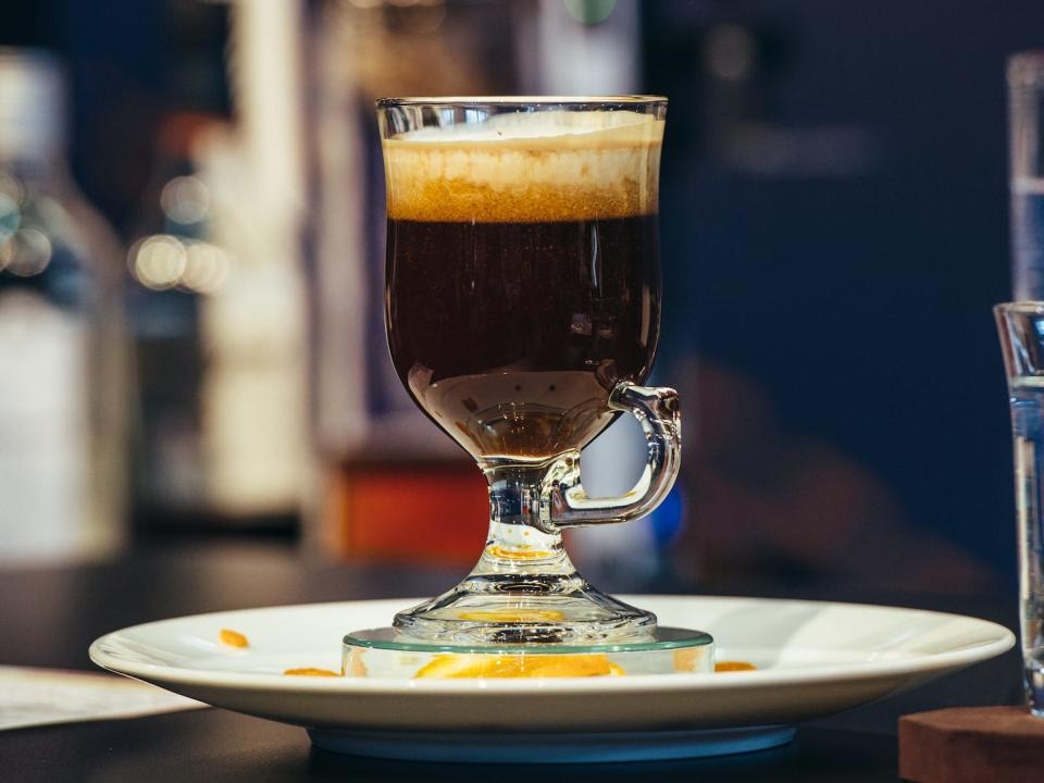 an irish coffee sitting on a saucer on a bar