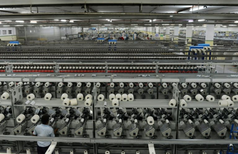 Indian employees work at a textile factory in Khatraj village, some 20 kms from Ahmedabad