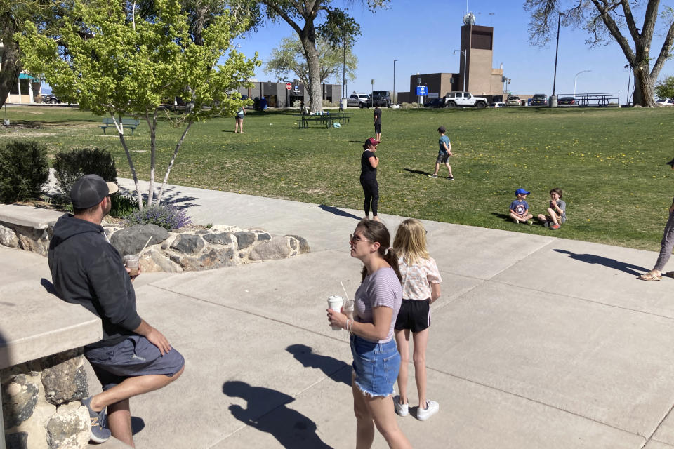 Families flocked to a public park in downtown Los Alamos, N.M., on Thursday, May 12, 2022, during a weeklong public school closure because of nearby wildfire. The blaze crept has been creeping closer to the mesa-top city and companion Los Alamos National Laboratory that analyzes global threats of disease, warfare and natural disasters. Scientists at Los Alamos are using supercomputers and ingenuity to improve wildfire forecasting and forest management amid drought and climate change in the American West. (AP Photo/Morgan Lee)