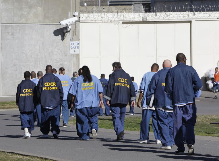 FILE - Inmates walk through the exercise yard at California State Prison Sacramento, near Folsom, Calif., on Feb. 26, 2013. Former California correctional officer Arturo Pacheco, who was fired from his job in 2018, pleaded guilty Monday, July 25, 2022, to federal charges stemming from two on-duty assaults in 2016. A second correctional officer who also was fired in 2018 previously pleaded guilty to submitting a false report about Pacheco's actions. Both officers worked at California State Prison, Sacramento, which neighbors Folsom State Prison east of Sacramento. (AP Photo/Rich Pedroncelli, File)