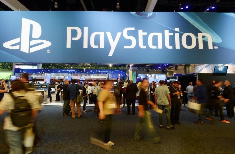 Attendees walk past the Sony Playstation booth at the 2014 Electronic Entertainment Expo, known as E3, in Los Angeles, California June 11, 2014. REUTERS/Kevork Djansezian