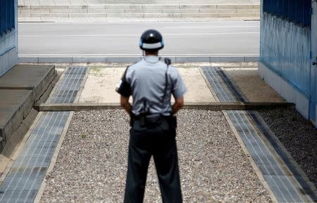 A concrete border is seen as a South Korean soldier stands guard at the truce village of Panmunjom, South Korea July 19, 2017. REUTERS/Kim Hong-Ji/Files