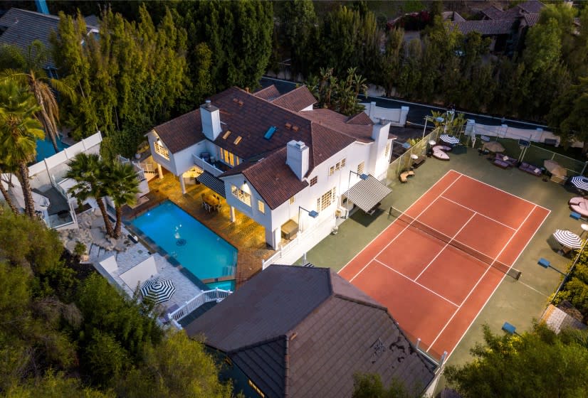 The double-gated estate includes a Hamptons-style main home, three-story guesthouse, swimming pool and tennis court on over an acre.