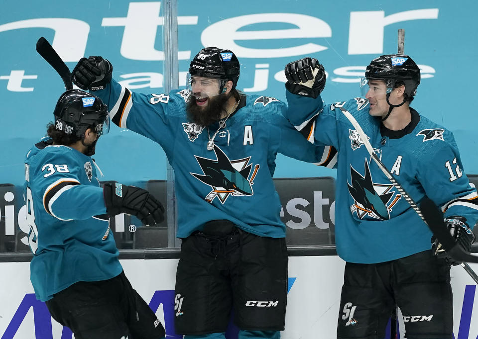 San Jose Sharks defenseman Brent Burns, center, celebrates with teammates Patrick Marleau (12) and Mario Ferraro (38) after scoring a goal against Minnesota Wild during the first period of an NHL hockey game in San Jose, Calif., Monday, Feb. 22, 2021. (AP Photo/Tony Avelar)