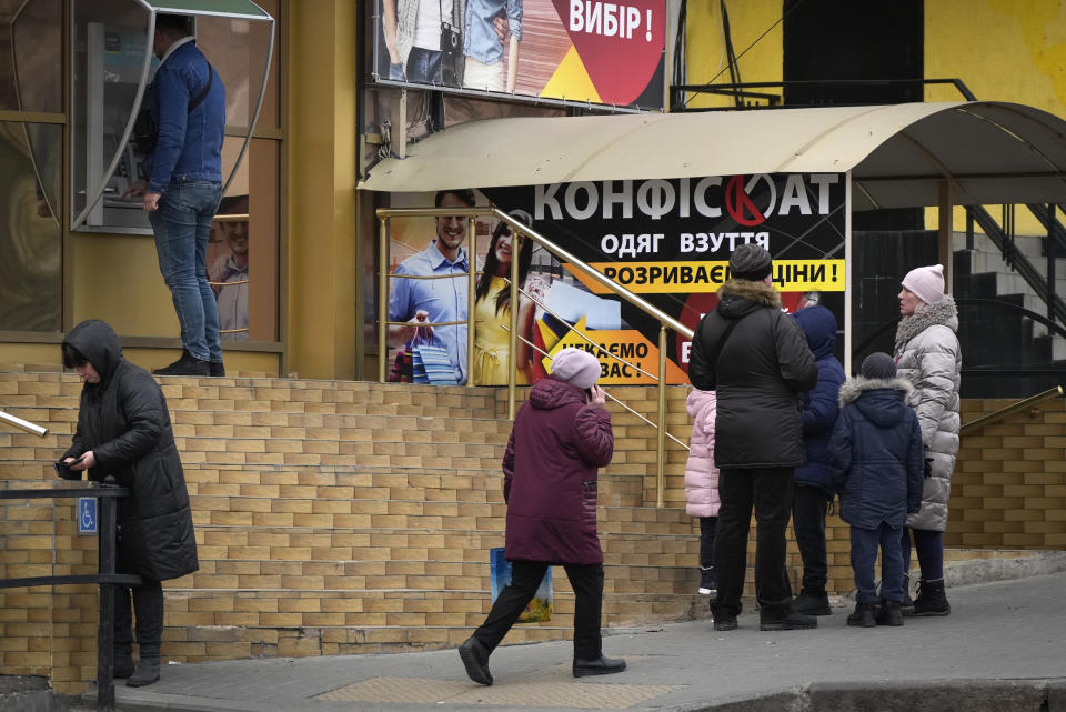 People stand in line to withdraw money from an ATM in Nikolaev, Ukraine, Tuesday, March 1, 2022. Russia on Tuesday stepped up shelling of Kharkiv, Ukraine's second-largest city, pounding civilian targets there. Casualties mounted and reports emerged that more than 70 Ukrainian soldiers were killed after Russian artillery recently hit a military base in Okhtyrka, a city between Kharkiv and Kyiv, the capital. (AP Photo/Sergei Grits)