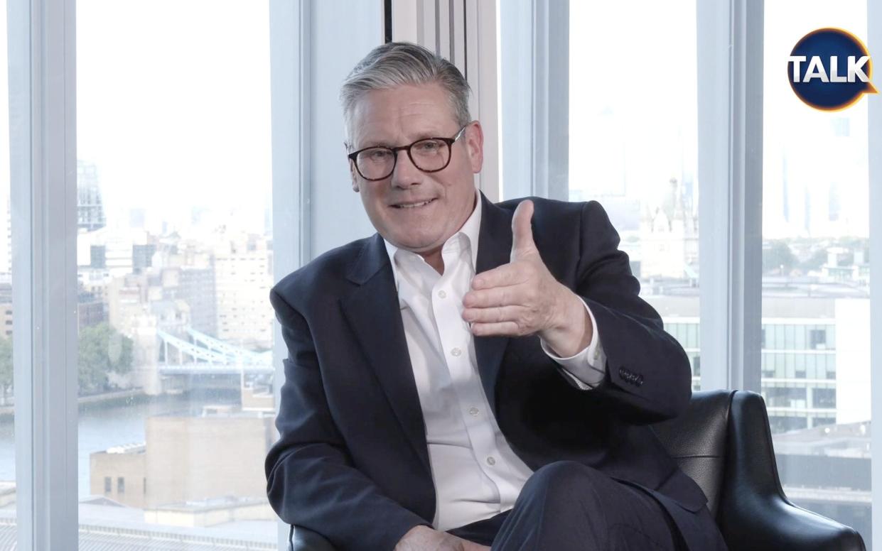 Sir Keir gestures in front of a background view of London