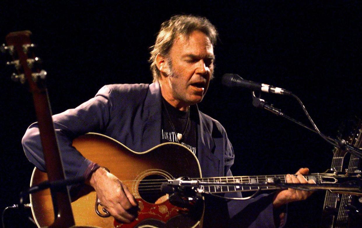 Neil Young belts out a tune during his solo concert at The Grand Ole Opry House in Nashville on April 15, 1999. Young introduced his song, “Homegrown,” during the concert.