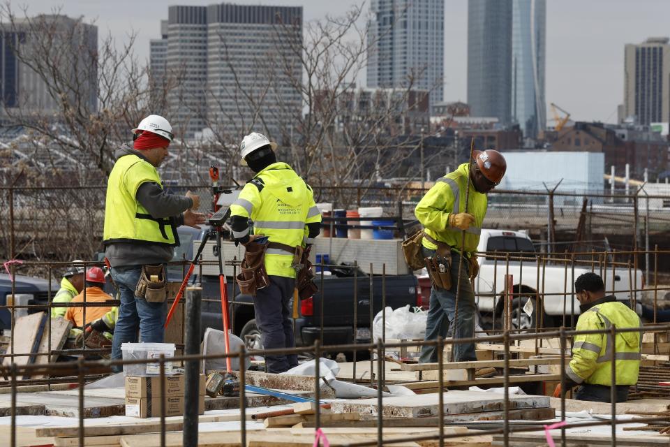 Construction workers prepare a recently poured concrete foundation, Friday, March 17, 2023, in Boston. On Friday, he U.S. government issues the March jobs report. (AP Photo/Michael Dwyer)