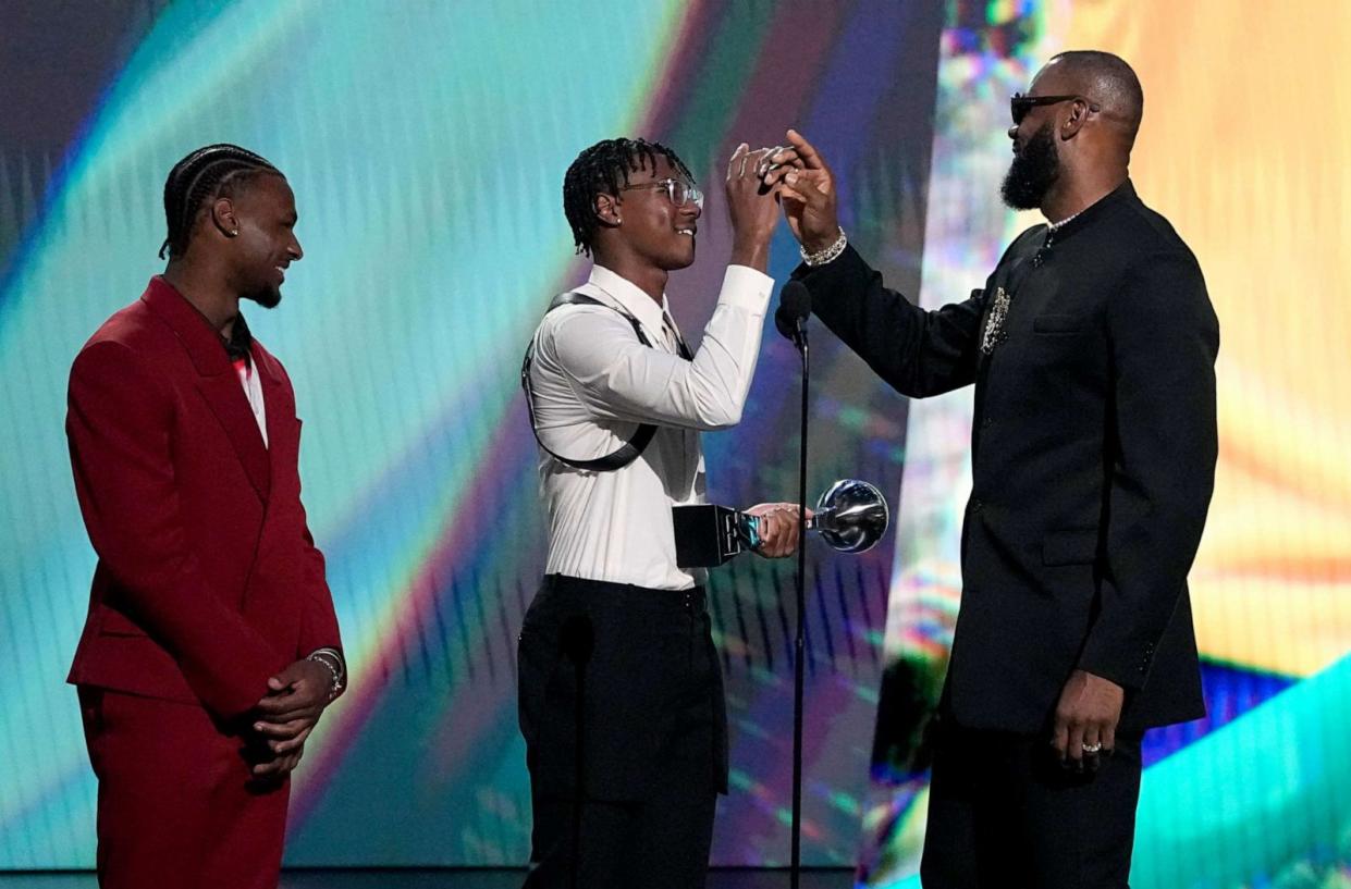 PHOTO: LeBron James, of the Los Angeles Lakers, from right, accepts the award for best record-breaking performance from his sons, Bryce James, and Bronny James at the ESPY Awards on Wednesday, July 12, 2023, at the Dolby Theatre in Los Angeles. (Mark Terrill/Invision/AP, FILE)