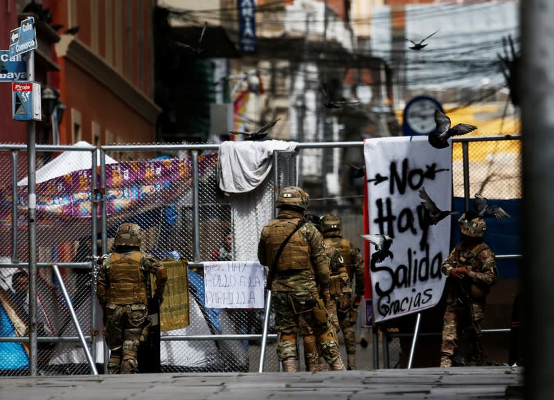 Bolivian soldiers stand next to a barricade in La Paz