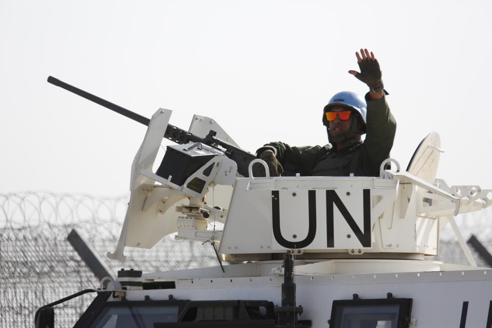 A UN soldier waves as UN vehicle enters Syria in Quneitra crossing in the Israeli controlled Golan Heights , Monday, Oct. 15, 2018. The crossing between Syria and the Israeli-occupied Golan Heights reopened for U.N. observers who had left the area four years ago because of the fighting there. (AP Photo/Ariel Schalit)