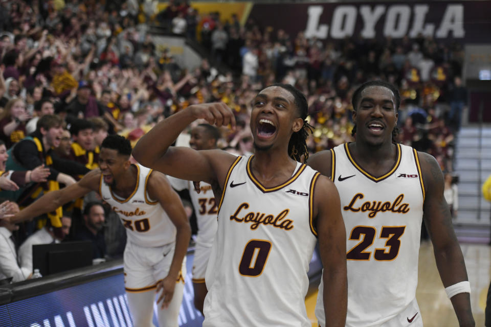 Loyola Chicago's Des Watson (0), Philip Alston, (23) and Patrick Mwamba (30) celebrate the team's 77-72 win over Dayton in an NCAA college basketball game Friday, March 1, 2024, in Chicago. (AP Photo/Paul Beaty)