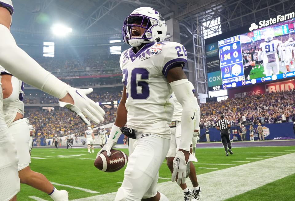 Dec 31, 2022; Glendale, Arizona, USA; TCU Horned Frogs safety Bud Clark (26) celebrates after returning an interception for a touchdown against the Michigan Wolverines during the Vrbo Fiesta Bowl at State Farm Stadium. Mandatory Credit: Joe Rondone-Arizona Republic