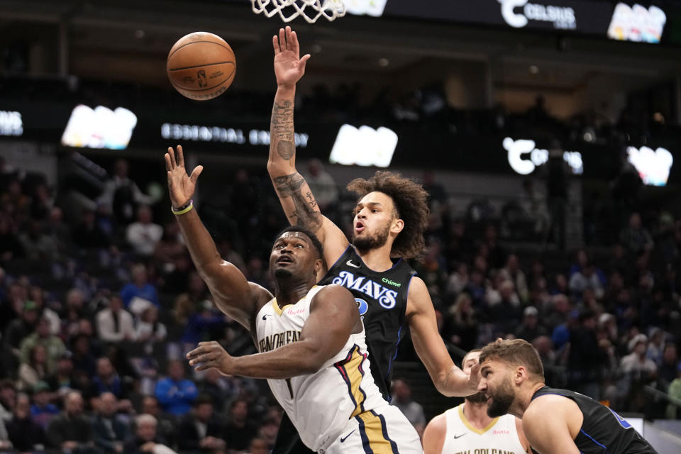 New Orleans Pelicans forward Zion Williamson (1) takes a shot after getting past Dallas Mavericks center Dereck Lively II, rear, and forward Maxi Kleber, right, in the first half of an NBA basketball game in Dallas, Monday, Jan. 15, 2024. (AP Photo/Tony Gutierrez)