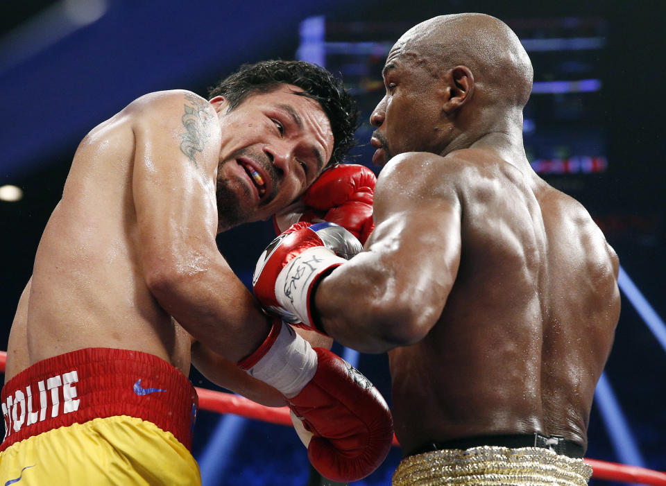 FILE – This May 2, 2015 file photo shows Manny Pacquiao from the Philippines, left, trading punches with Floyd Mayweather Jr., during their welterweight title fight in Las Vegas. (AP Photo/John Locher, File)