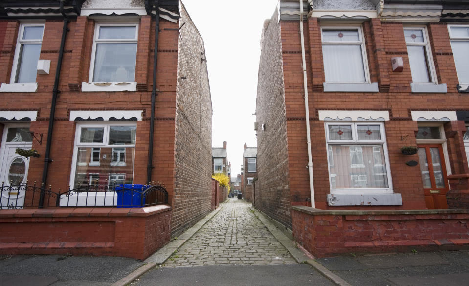 "Street of row houses / terraced houses with alleyway between blocks. This is Moss Side, Manchester, UK."