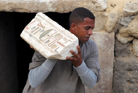 A worker carries an artefact outside the tomb of Khufu-Imhat, at the Saqqara area near its necropolis, in Giza, Egypt November 10, 2018. REUTERS/Mohamed Abd El Ghany