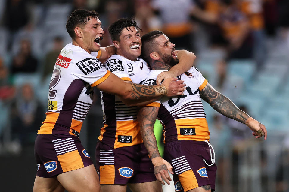 Pictured far right, Brisbane's Adam Reynolds celebrates scoring a try against his former club South Sydney.