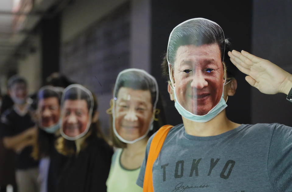 Protesters wear masks of Chinese President Xi Jinping in Hong Kong, Friday, Oct. 18, 2019. Hong Kong pro-democracy protesters are donning cartoon/superheroes masks as they formed a human chain across the semiautonomous Chinese city, in defiance of a government ban on face coverings. (AP Photo/Kin Cheung)