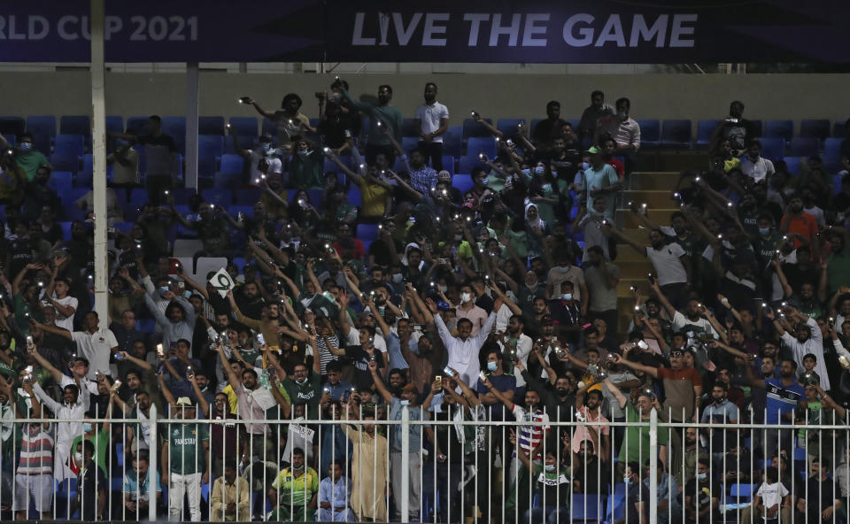 Pakistan's cricket fans light up their mobile torches and cheer for their team during the Cricket Twenty20 World Cup match between New Zealand and Pakistan in Sharjah, UAE, Tuesday, Oct. 26, 2021. (AP Photo/Aijaz Rahi)