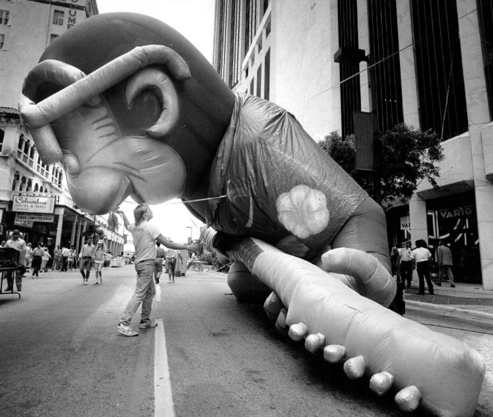 Bill Murphy, a disc jockey at 97GTR, struggles to lift his stations 30-foot inflatable gorilla mascot into position at the international food bazaar on Flagler Street in downtown Miami in 1987.