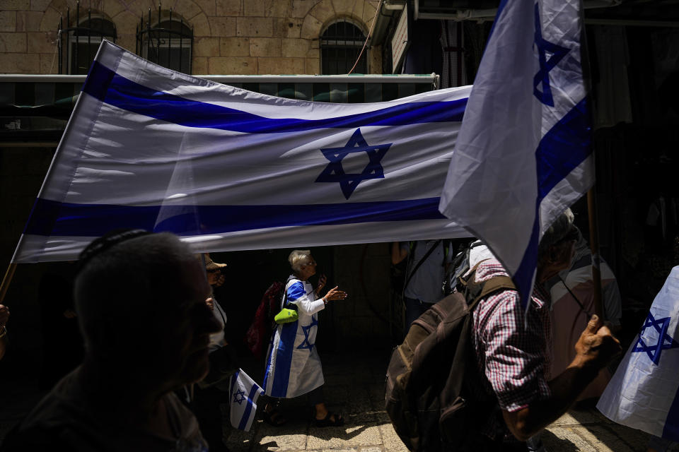 Israelis wave national flags ahead of a march marking Jerusalem Day, an Israeli holiday celebrating the capture of east Jerusalem in the 1967 Mideast war, in Jerusalem's Old City, Thursday, May 18, 2023. (AP Photo/Ohad Zwigenberg)