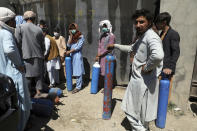Men wait outside a privately owned oxygen factory to get their oxygen cylinders refilled, in Kabul, Afghanistan, Saturday, June 19, 2021. Health officials say Afghanistan is fast running out of oxygen as a deadly third surge of COVID worsen. (AP Photo/Rahmat Gul)