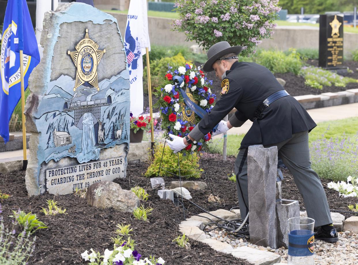 Stark County sheriff's deputy Jordan Carter places a wreath for all of Stark County's fallen officers at the Stark County Sheriff's Office Peace Officer Memorial Ceremony held Friday at the Stark County Safety Building in Canton.