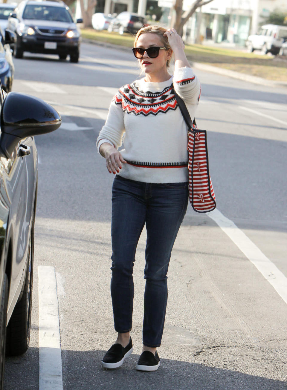 Reese Witherspoon wears a Fair Isle sweater, blue skinny jeans, and slip-ons on Dec. 13, 2015 in Los Angeles, California.