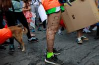 An environmental activist with the words "Climate Justice" written on her leg participates in a Global Climate Strike near the Ministry of Natural Resources and Environment office in Bangkok