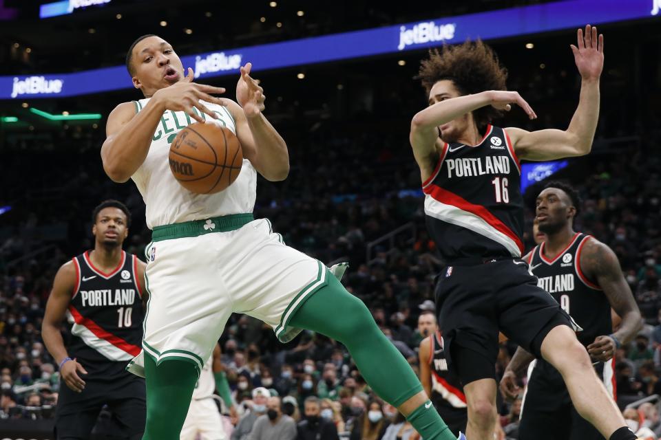 Boston Celtics' Grant Williams comes down with a rebound next to Portland Trail Blazers' CJ Elleby (16) during the first half of an NBA basketball game Friday, Jan. 21, 2022, in Boston. (AP Photo/Michael Dwyer)