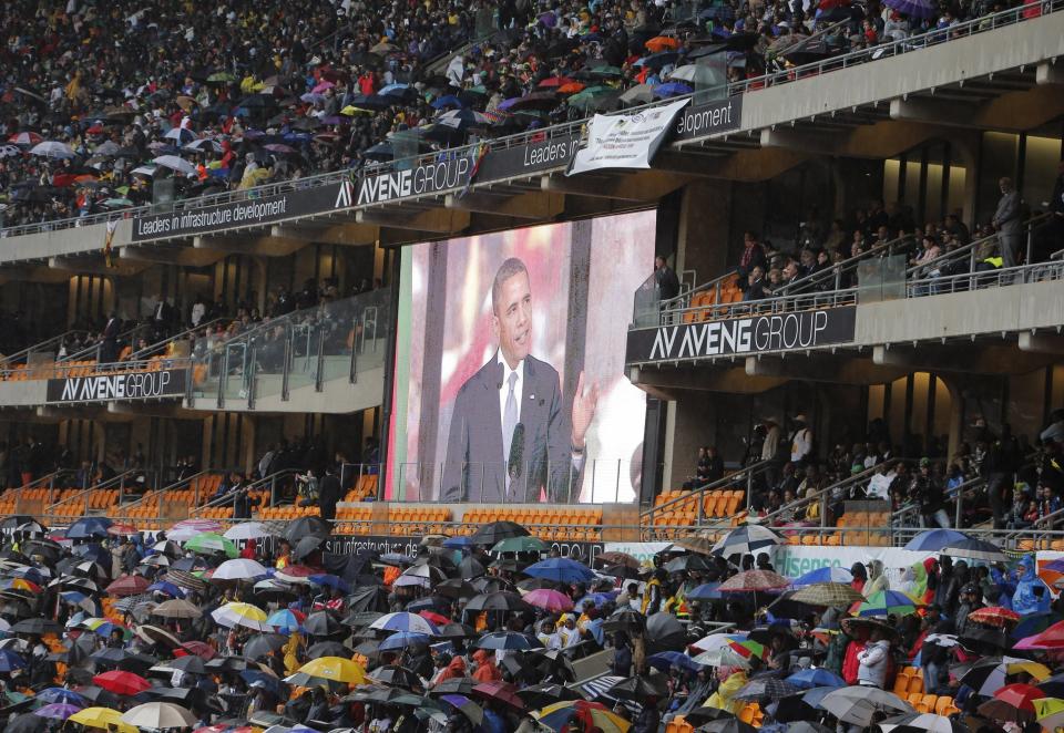 An image of President Barrack Obama is flashed on a screen as he makes his speech during the memorial service for former South African president Nelson Mandela at the FNB Stadium in Soweto, near Johannesburg, South Africa, Tuesday Dec. 10, 2013. (AP Photo/Tsvangirayi Mukwazhi)