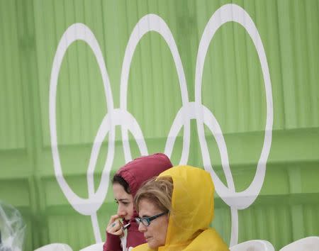 2016 Rio Olympics - Beach Volleyball - Men's Preliminary - Beach Volleyball Arena - Rio de Janeiro, Brazil - 10/08/2016. Fans watch beach volleyball on a rainy day. REUTERS/Ricardo Moraes