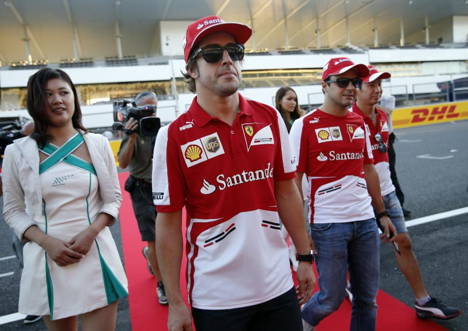 Ferrari Formula One driver Fernando Alonso of Spain (C), teammate Felipe Massa of Brazil (2nd R) and test driver Kamui Kobayashi of Japan (R) attend an autograph session for fans at the Suzuka circuit October 10, 2013, ahead of Sunday's Japanese F1 Grand Prix. REUTERS/Issei Kato (JAPAN - Tags: SPORT MOTORSPORT F1)