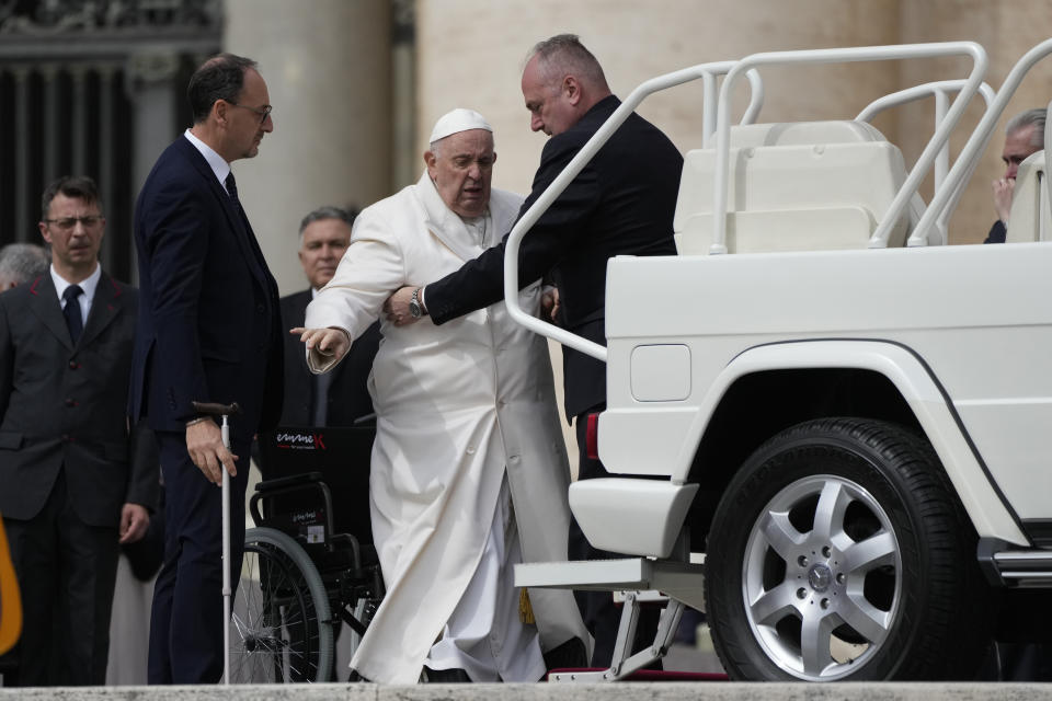 Pope Francis helped to get on his car at the end of weekly general audience in St. Peter's Square, at the Vatican, Wednesday, March 29, 2023. Pope Francis went to a Rome hospital on Wednesday for some previously scheduled tests, slipping out of the Vatican after his general audience and before the busy start of Holy Week this Sunday. (AP Photo/Alessandra Tarantino)