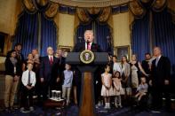 U.S. President Donald Trump calls on Republican Senators to move forward and vote on a healthcare bill to replace the Affordable Care Act, as people negatively affected by the law stand behind him, in the Blue Room of the White House in Washington, U.S., July 24, 2017. REUTERS/Joshua Roberts/Files