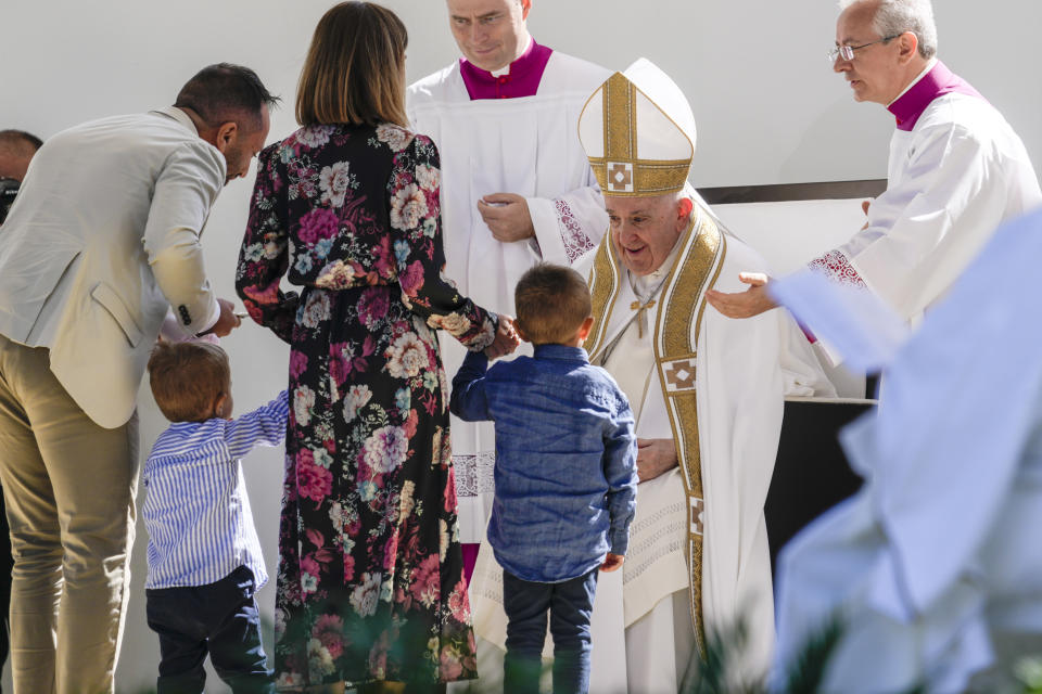 Pope Francis meets a family as he celebrates mass in front of the St. Mary in Collemaggio Basilica, in L'Aquila, central Italy, Sunday, Aug. 28, 2022. Pope Francis will be the first pope since Celestine V to open the St. Mary in Collemaggio Basilica Holy Door, the first in history, established with the Bull of Forgiveness of 29 September 1294 by Pope Celestine V, and start the jubilee of forgiveness. (AP Photo/Domenico Stinellis)